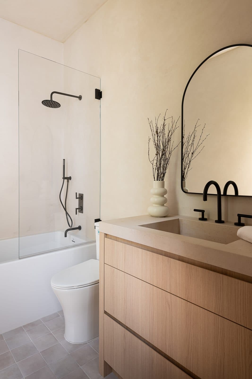 A bathroom finished in Meoded Concretta microcement, shower wall and vanity wall in one seamless surface