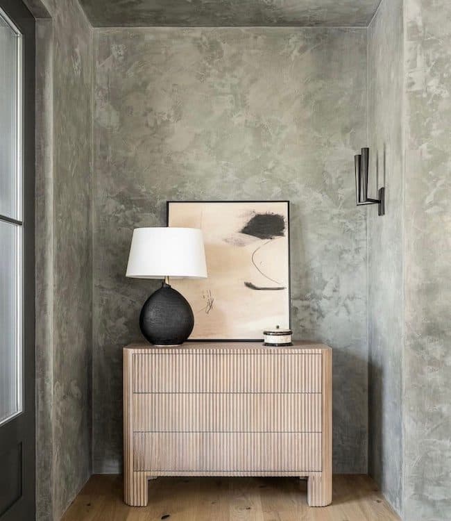 An alcove finished in Meoded Stucco Lamundo, polished plaster behind a wood dresser and lamp